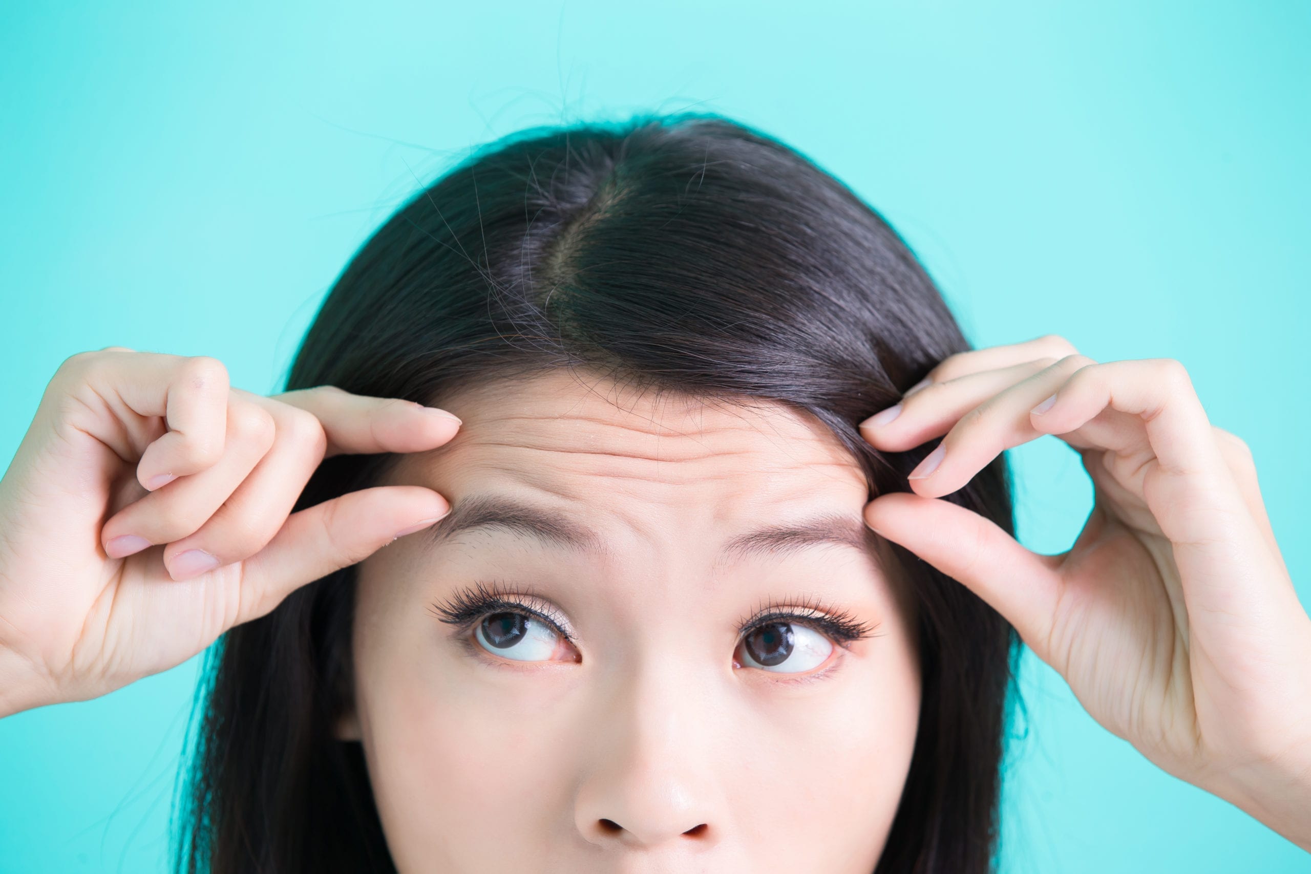 Woman Examining Forehead Wrinkles